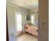 Bathroom with a vintage vanity, tiled floors, a doorway to the outside, and large mirrors at 18316 Oxenham Ave, Spring Hill, FL 34610