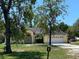 Quaint single-story home with mature trees and an attached two-car garage, set back from the street at 18316 Oxenham Ave, Spring Hill, FL 34610