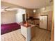 Kitchen featuring tile floors, an island, appliances, and access to an adjacent carpeted room with a ceiling fan at 18316 Oxenham Ave, Spring Hill, FL 34610