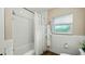 Bright bathroom featuring a shower over tub, white tiled walls, and a window providing natural light at 105 17Th Ne Ave, St Petersburg, FL 33704