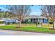 Charming single-story home featuring a manicured lawn, complemented by a stylish black fence and mature trees at 105 17Th Ne Ave, St Petersburg, FL 33704