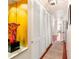 Hallway featuring hardwood floors, a decorative rug, a bright yellow accent wall, and closet with louvered doors at 105 17Th Ne Ave, St Petersburg, FL 33704
