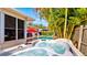Backyard hot tub with pool in background surrounded by mature tropical foliage and a fenced perimeter at 105 17Th Ne Ave, St Petersburg, FL 33704