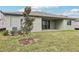 View of the home's backyard featuring a patio, green grass and an immature tree at 1832 Draughton Dr, Zephyrhills, FL 33541