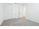 Bright bedroom featuring neutral carpet, white walls, and closet space at 1832 Draughton Dr, Zephyrhills, FL 33541