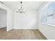 Bright dining room featuring tile floors, a modern chandelier, and a large window with lots of natural light at 1832 Draughton Dr, Zephyrhills, FL 33541