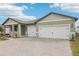 Lovely one-story home with three-car garage and appealing brick driveway and front yard landscaping at 1832 Draughton Dr, Zephyrhills, FL 33541