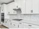 Close up of the eat-in kitchen with white cabinets, counter tops and backsplash at 1832 Draughton Dr, Zephyrhills, FL 33541