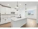 Bright eat-in kitchen features white cabinets, quartz counters and a large island at 1832 Draughton Dr, Zephyrhills, FL 33541
