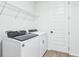 This laundry room features modern appliances, wire shelving for storage, and a sleek door at 1832 Draughton Dr, Zephyrhills, FL 33541