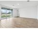 Spacious living room with wood-look tile floors and large sliding glass doors to the backyard at 1832 Draughton Dr, Zephyrhills, FL 33541