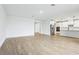 Bright, open living room with wood-look tile leading into the kitchen with stainless appliances at 1832 Draughton Dr, Zephyrhills, FL 33541