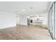 Bright, open living room with wood-look tile leading into the eat-in kitchen with white cabinets at 1832 Draughton Dr, Zephyrhills, FL 33541