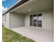 Covered patio area with sliding glass doors overlooking the lawn at 1832 Draughton Dr, Zephyrhills, FL 33541