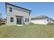 View of a spacious backyard and the home's siding, windows, and sliding glass door at 1852 Brekey Way, Zephyrhills, FL 33541