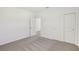 A bedroom featuring gray carpet, closet with sliding doors, and access to other rooms at 1852 Brekey Way, Zephyrhills, FL 33541