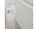 Hallway with tile floors leading to an open floor plan with great natural light and neutral wall paint at 1852 Brekey Way, Zephyrhills, FL 33541