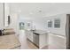 Open concept kitchen with stainless steel appliances, granite countertops, white cabinetry, and an island at 1852 Brekey Way, Zephyrhills, FL 33541