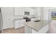 Bright kitchen featuring white cabinets, granite countertops, stainless steel appliances, and a large island at 1852 Brekey Way, Zephyrhills, FL 33541