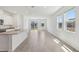 Bright open-plan living room and kitchen with tile flooring and sliding door access to the backyard at 1852 Brekey Way, Zephyrhills, FL 33541