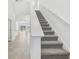 Carpeted staircase with white railing, connecting to an open space filled with neutral paint and ample light at 1852 Brekey Way, Zephyrhills, FL 33541