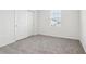 This carpeted bedroom has a closet with sliding doors and a window with blinds at 1867 Draughton Dr, Zephyrhills, FL 33541