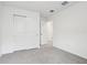 Carpeted bedroom featuring a closet with sliding doors and an open doorway to another room at 1867 Draughton Dr, Zephyrhills, FL 33541
