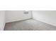 Neutral bedroom featuring soft gray carpet, white baseboards, and a window for natural light at 1867 Draughton Dr, Zephyrhills, FL 33541