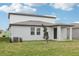 Two-story home with a backyard, modern siding, a covered entryway, and a well-maintained lawn at 1867 Draughton Dr, Zephyrhills, FL 33541