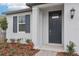 Inviting front entrance featuring a stylish dark door and manicured landscaping around the house at 1867 Draughton Dr, Zephyrhills, FL 33541