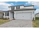 Charming two-story home with neutral paint, complemented by a two-car garage and landscaped yard at 1867 Draughton Dr, Zephyrhills, FL 33541