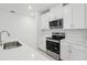 Modern kitchen featuring stainless steel appliances and white cabinetry at 1867 Draughton Dr, Zephyrhills, FL 33541