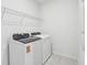 Bright laundry room with modern appliances and overhead shelving at 1867 Draughton Dr, Zephyrhills, FL 33541