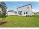Spacious backyard with a well-manicured lawn, providing a serene outdoor space for leisure and recreation next to the modern home at 1868 Brekey Way, Zephyrhills, FL 33541