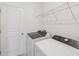 Well-equipped laundry room includes modern washer, dryer, and wire shelving for storage at 1868 Brekey Way, Zephyrhills, FL 33541