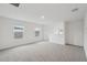 Spacious living room featuring neutral carpet, two windows, and an open railing at 1868 Brekey Way, Zephyrhills, FL 33541