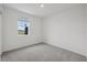 Clean bedroom featuring neutral carpet, bright window, and ample natural light at 1886 Draughton Dr, Zephyrhills, FL 33541