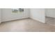 Cozy bedroom with light floors and a window view; includes a doorway to carpeted area at 1886 Draughton Dr, Zephyrhills, FL 33541