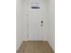 Bright entryway with white door and modern hardware, leading to wood floors at 1886 Draughton Dr, Zephyrhills, FL 33541