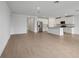 Bright, open-concept kitchen with white cabinets, stainless steel appliances, and wood-look flooring at 1886 Draughton Dr, Zephyrhills, FL 33541