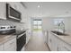 Contemporary kitchen boasts granite countertops, stainless steel appliances, and a view of the pond at 1886 Draughton Dr, Zephyrhills, FL 33541