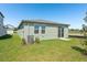 A backyard view of the home, with a grassy lawn and patio area at 1876 Brekey Way, Zephyrhills, FL 33541