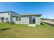 Backyard view of the home, featuring a lawn and patio at 1876 Brekey Way, Zephyrhills, FL 33541