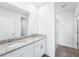 Bathroom features double sink vanity with granite countertops, white cabinets, and tiled walk-in shower at 1876 Brekey Way, Zephyrhills, FL 33541