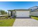Charming single-Gathering home with a well-maintained lawn and a paved driveway leading to a two-car garage at 1876 Brekey Way, Zephyrhills, FL 33541