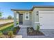 Charming home showcasing a covered front porch with manicured landscaping and attractive walkway at 1876 Brekey Way, Zephyrhills, FL 33541
