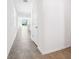 Hallway with tile floors leading to an open-concept layout with natural light streaming through windows at 1876 Brekey Way, Zephyrhills, FL 33541