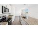 Kitchen featuring granite countertops, stainless steel appliances, and tiled floors at 1876 Brekey Way, Zephyrhills, FL 33541