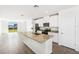Bright, open-concept kitchen with island, granite countertops, stainless steel appliances, and tile floors at 1876 Brekey Way, Zephyrhills, FL 33541