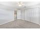 This is a bedroom with neutral carpet, a ceiling fan, and a large closet with folding doors at 4000 Barbary Ln, North Port, FL 34287